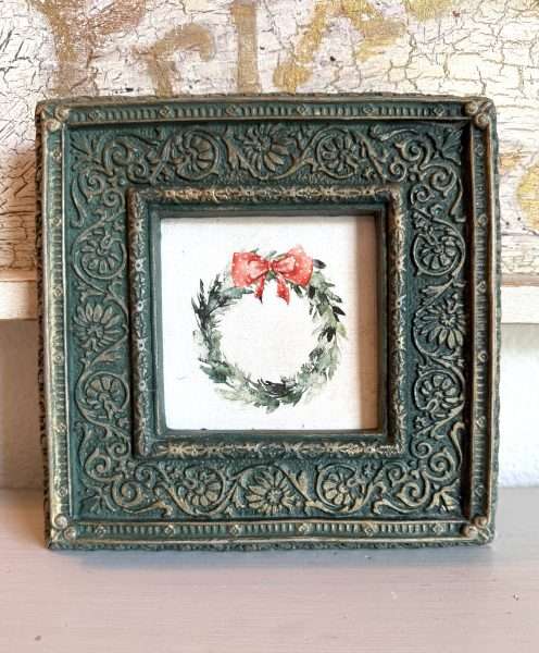 Upcycled vintage green frame painted with DIY Paint Eden by Karen Berg of Redoux Interiors featuring an Iron Orchid Designs (IOD) holiday wreath art with red bow — handmade Christmas décor idea.