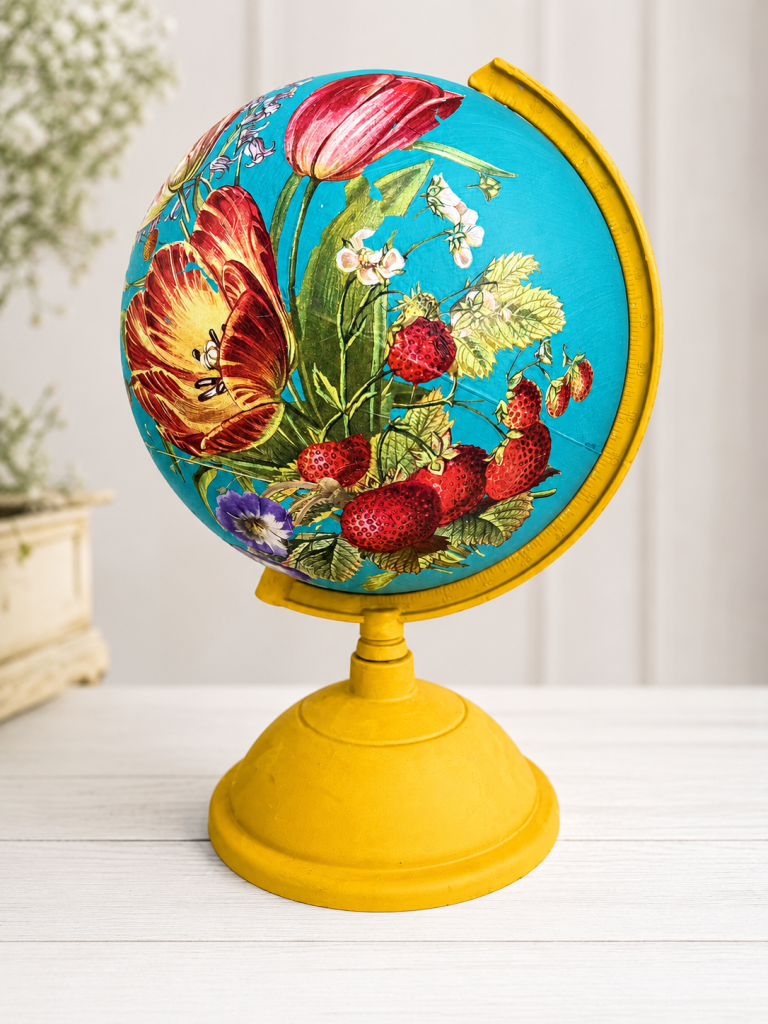 Decorative globe with a bright blue floral pattern on a yellow stand.